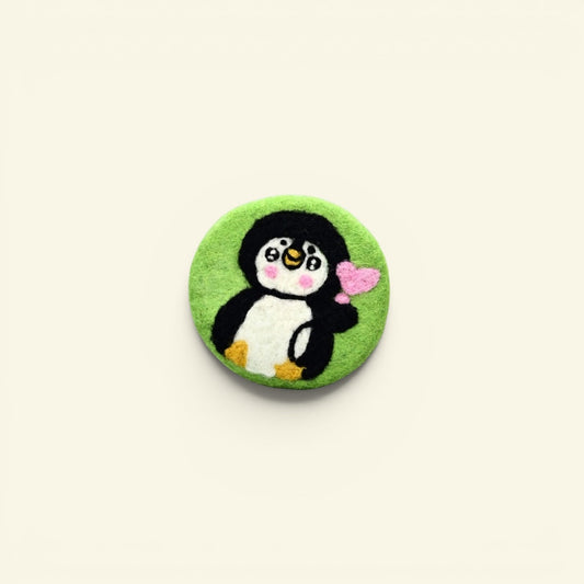 handmade wool felt penguin coaster, green colorway — embroidered penguin holding a heart, made in nepal