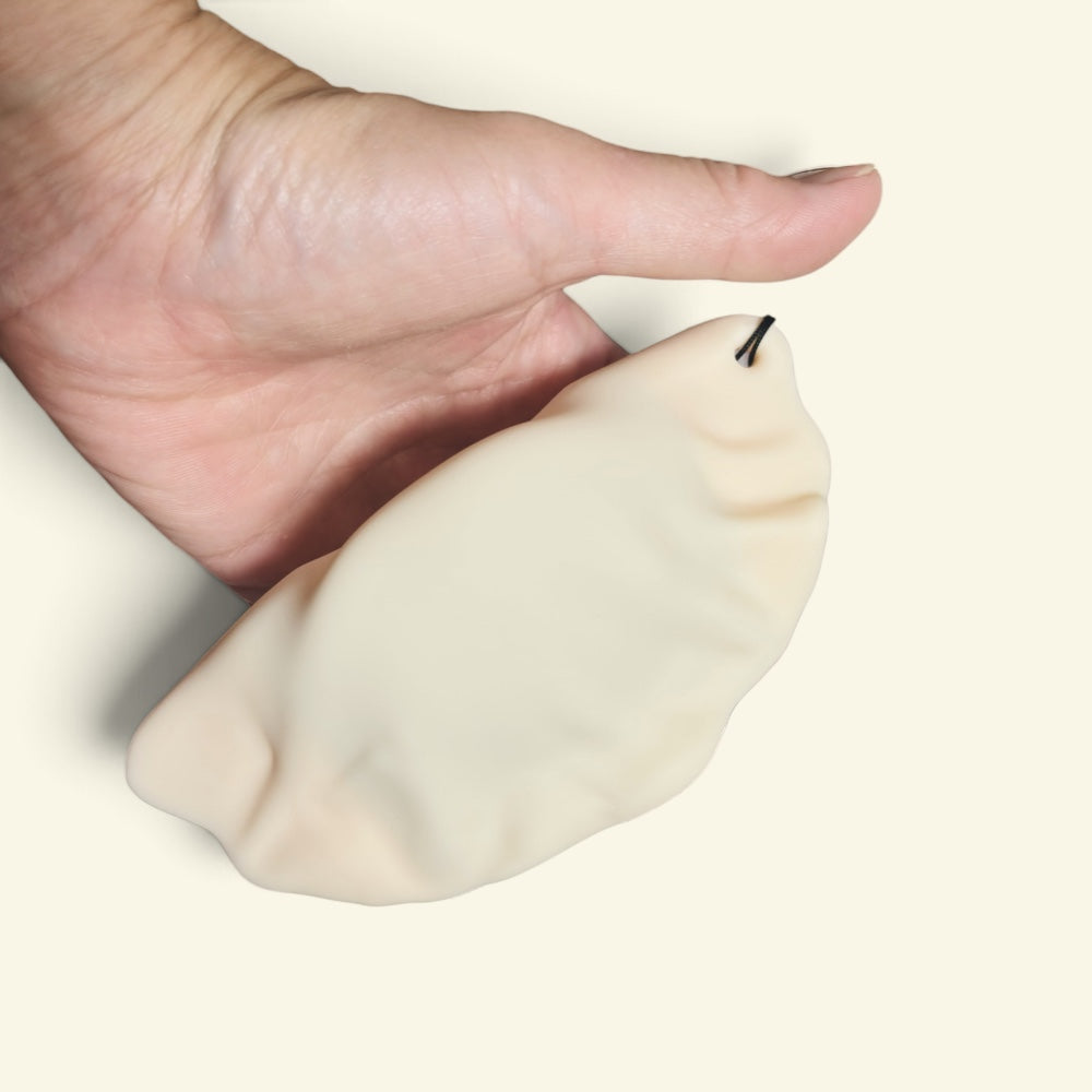 the dumpling dispenser next to a hand for scale