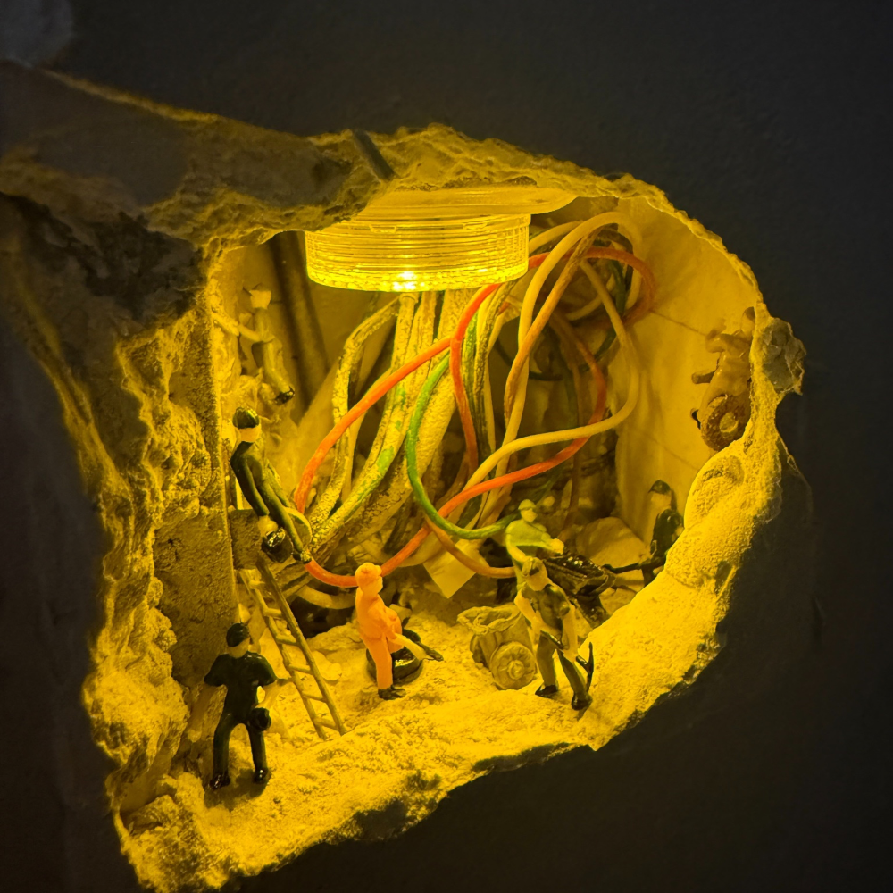 inside a wall hole glowing yellow, a round led light on the ceiling and 1:87 workers climbing ladders between tangled wires
