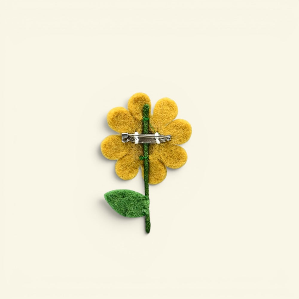 wool felt sunflower brooch detail — hand-needled petals and stitched seed pattern in the center