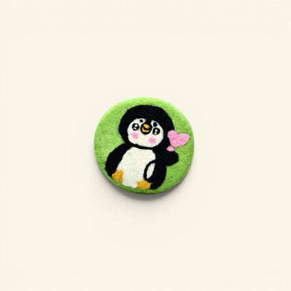 handmade wool felt penguin coaster, green colorway — embroidered penguin holding a heart, made in nepal