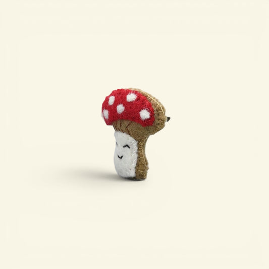 wool felt mushroom brooch detail — hand-stitched smile and cream stem