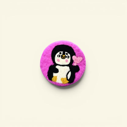 handmade wool felt penguin coaster, pink colorway — embroidered penguin holding a heart, made in nepal