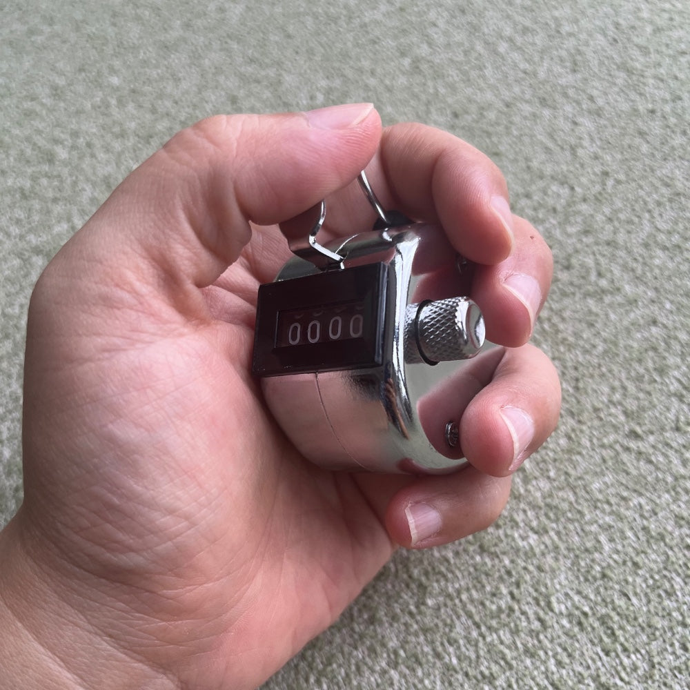the tally counter – metal, held in hand showing a reading of 0000, uggaz