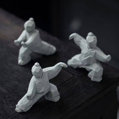 the slow masters – set of three faux-marble tai chi figurines on a dark wood table, uggaz