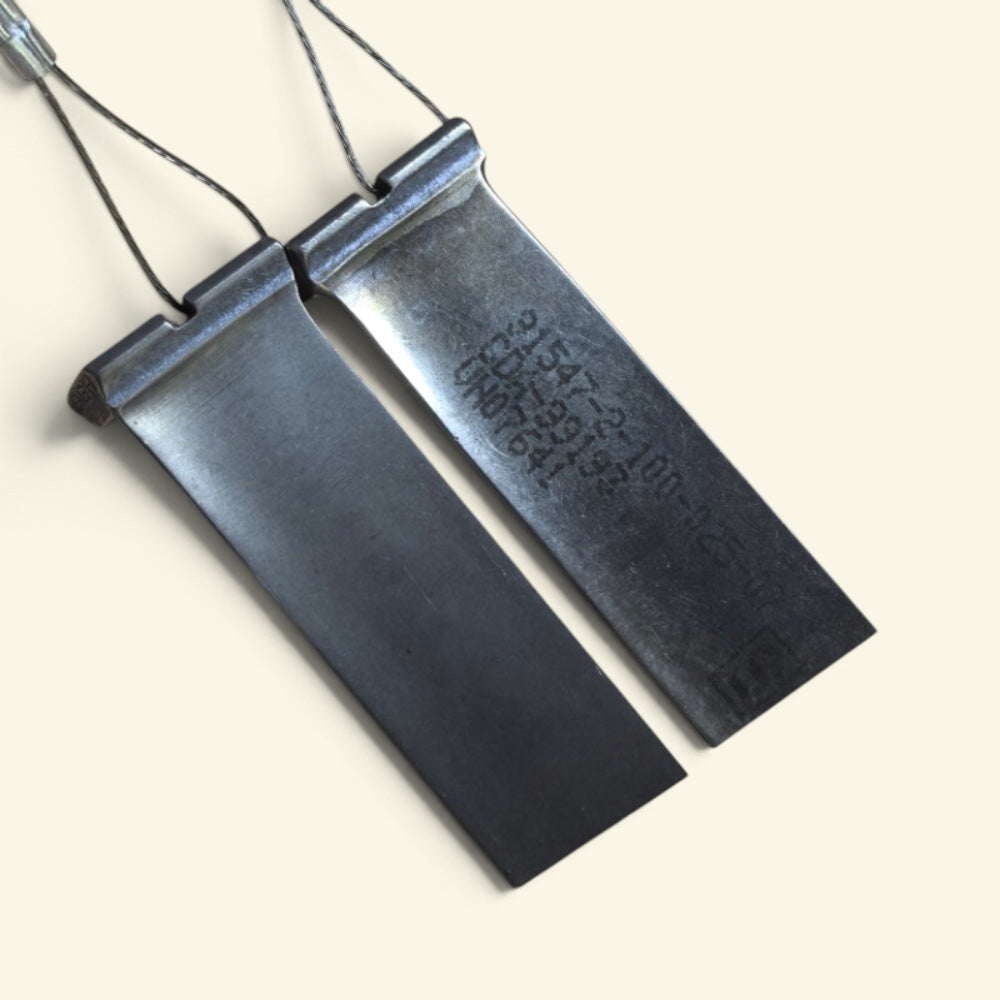 two compressor blade keychains side by side: an unmarked polished one and a marked one with a stamped part number, for comparison