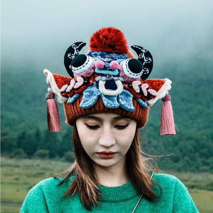 the ox head beanie in red worn outdoors, close detail against a foggy mountain landscape, uggaz