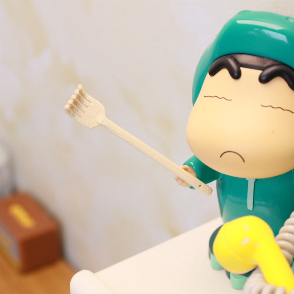 the tiny back scratcher held out by a small figurine on a miniature desk, uggaz
