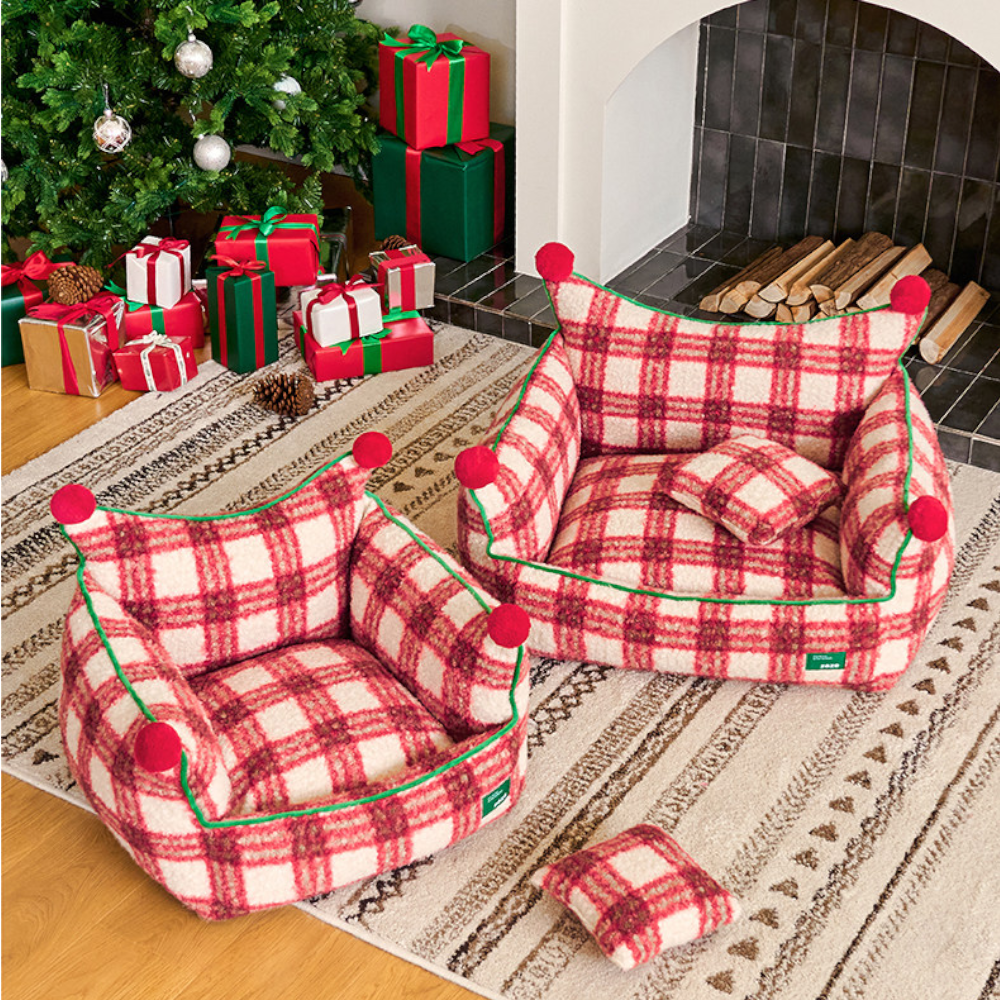 two plaid throne beds side by side with their plaid pillows, by a christmas tree and fireplace