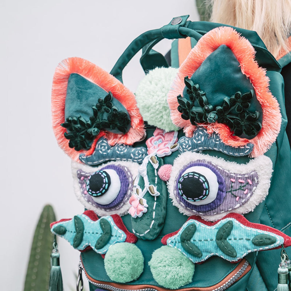close-up of the tiger pack worn on someone's back, showing the embroidered eyes and ear detail up close, uggaz