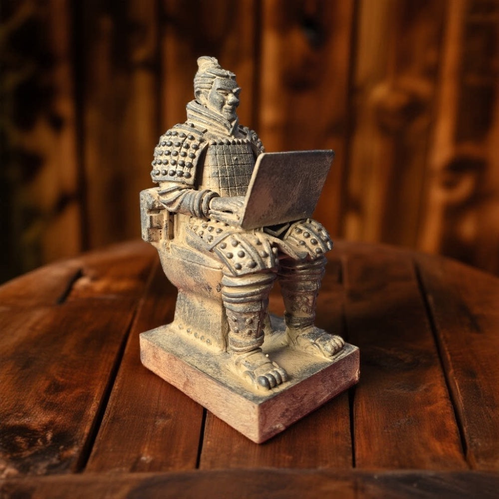terracotta warrior on a toilet with a laptop, standing on a rustic wooden table in warm light, topknot, scale armor and square base visible