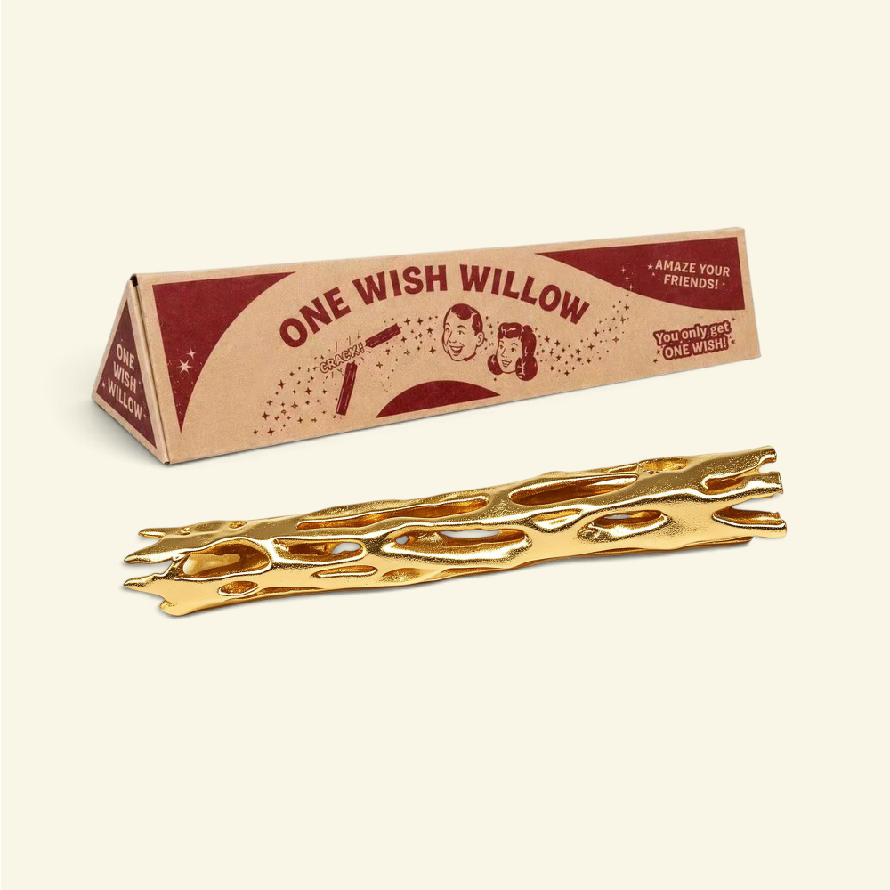 gold one wish willow snap stick lying in front of its triangular printed box