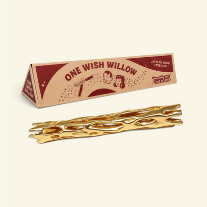 gold one wish willow snap stick lying in front of its triangular printed box