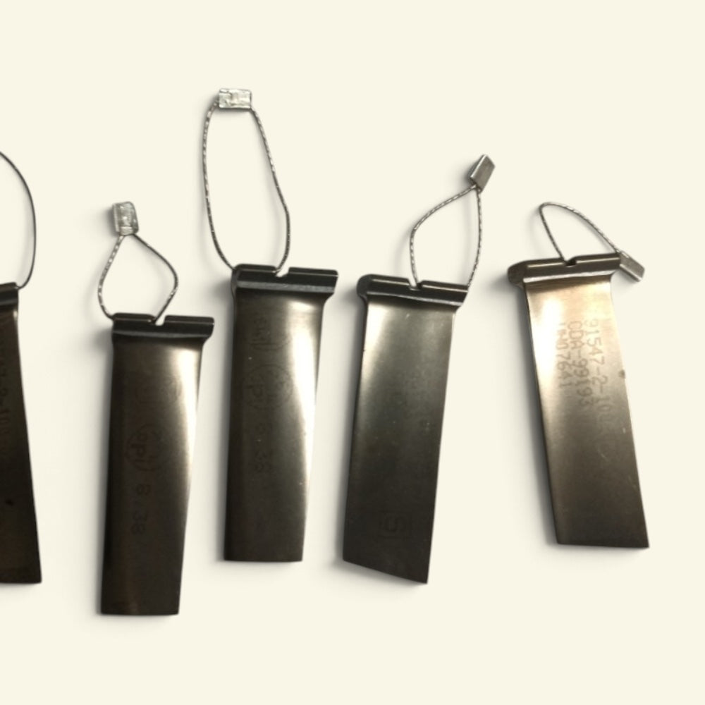 five t55 compressor blade keychains hanging in a row on steel wire loops