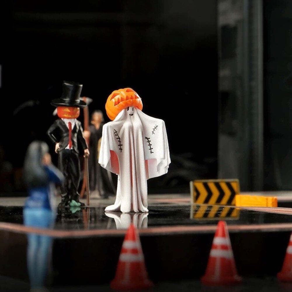the top-hat pumpkin gentleman and the pumpkin-head ghost on a dark miniature street with tiny orange traffic cones
