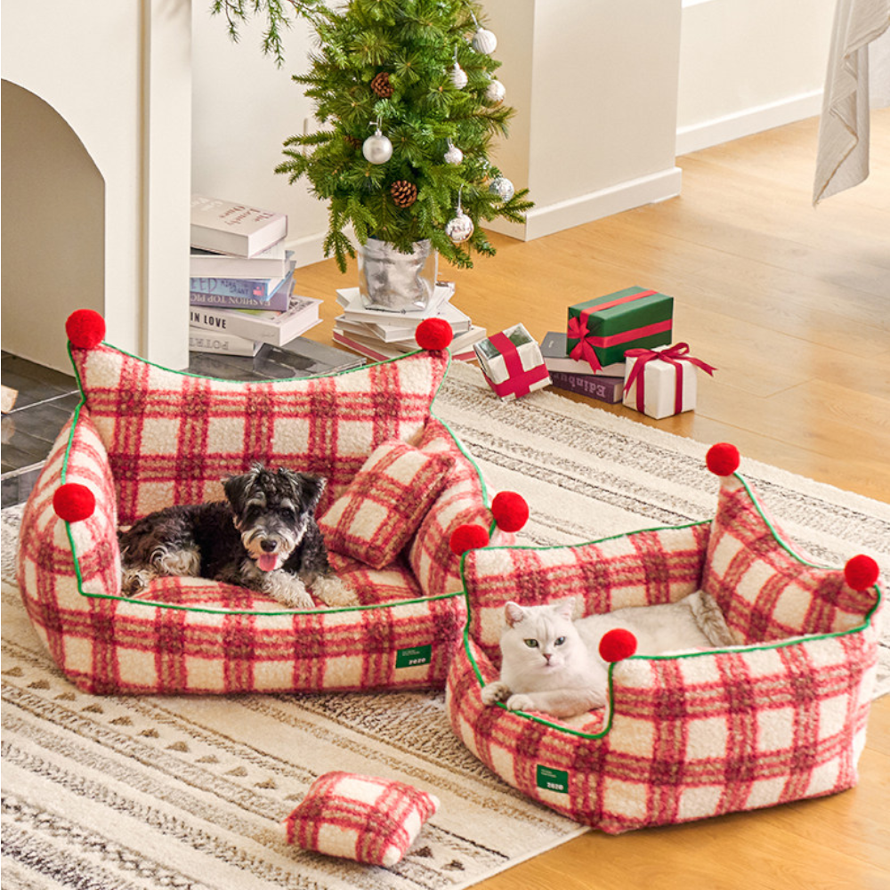 two plaid throne beds under a christmas tree, one with a schnauzer and one with a white cat
