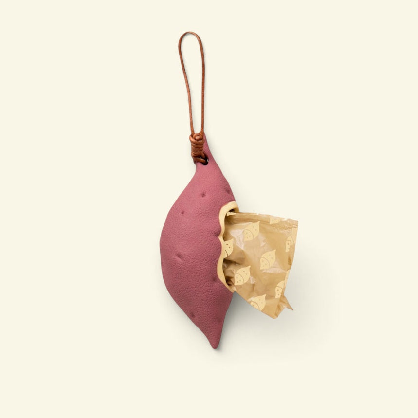 the yam sweet-potato-shaped silicone poop bag dispenser, open with a bag showing