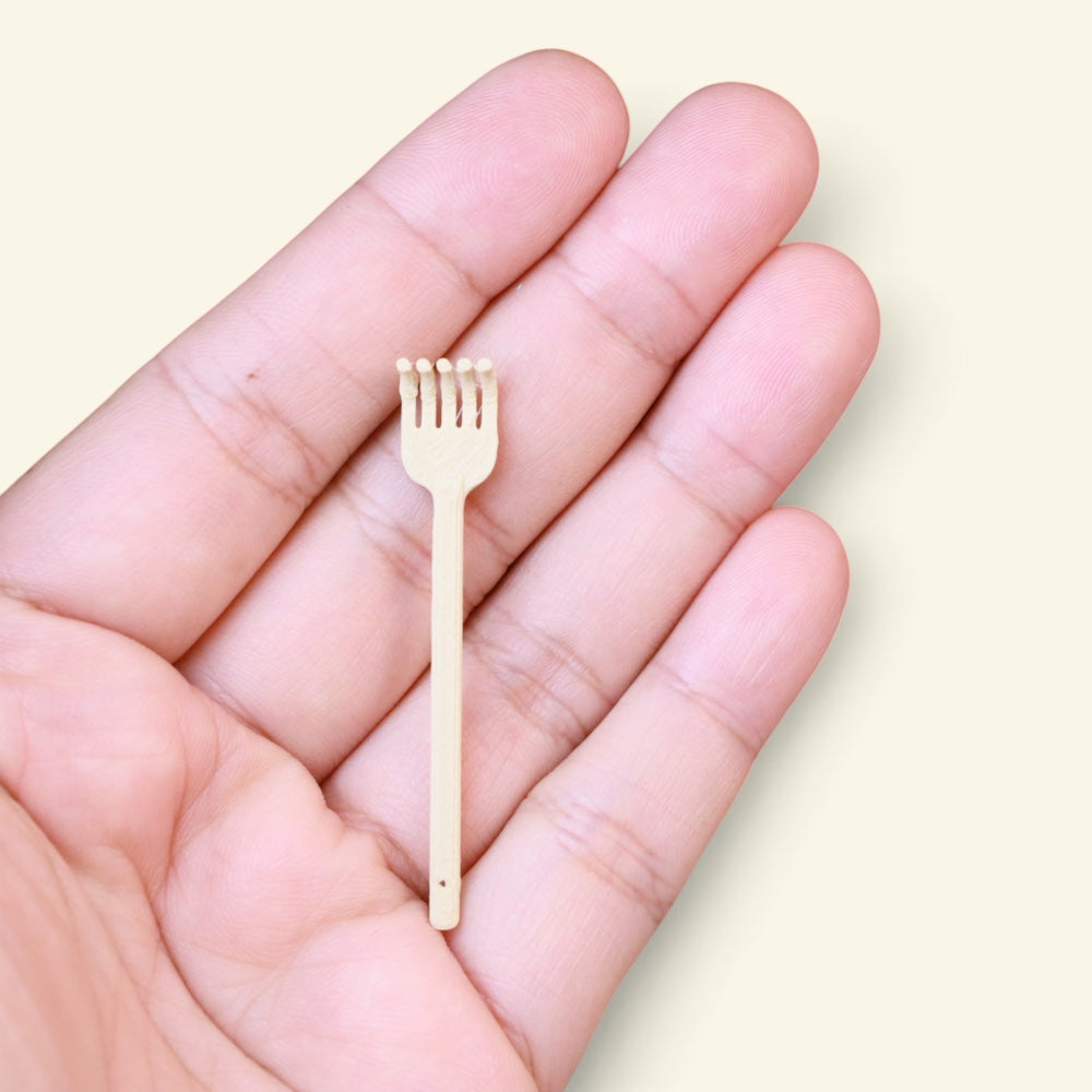 the tiny back scratcher lying in an open palm, showing how small 5 cm is, uggaz