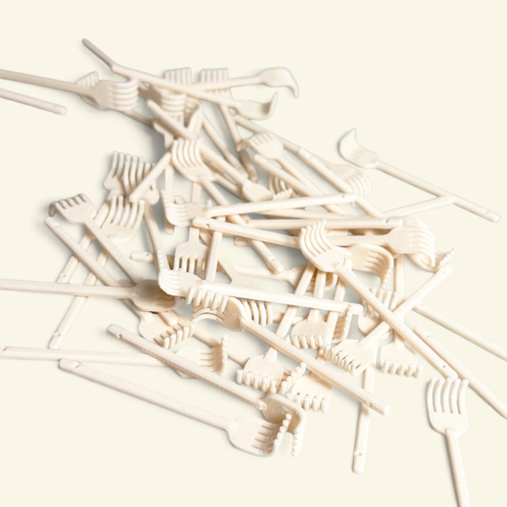 a pile of cream 3d printed miniature back scratchers, uggaz