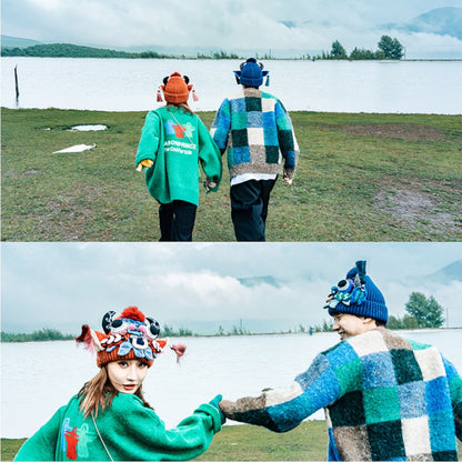 two photos of a couple by a lake, one wearing the red ox head beanie and the other the blue, holding hands, uggaz
