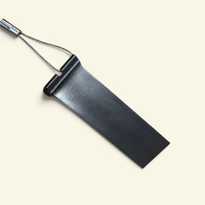 The Spare Part — an unmarked t55 turbine engine compressor blade keychain on a thin steel wire loop, on a cream background