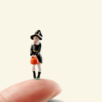 the 1:64 little witch standing on a fingertip, about 0.9 in tall