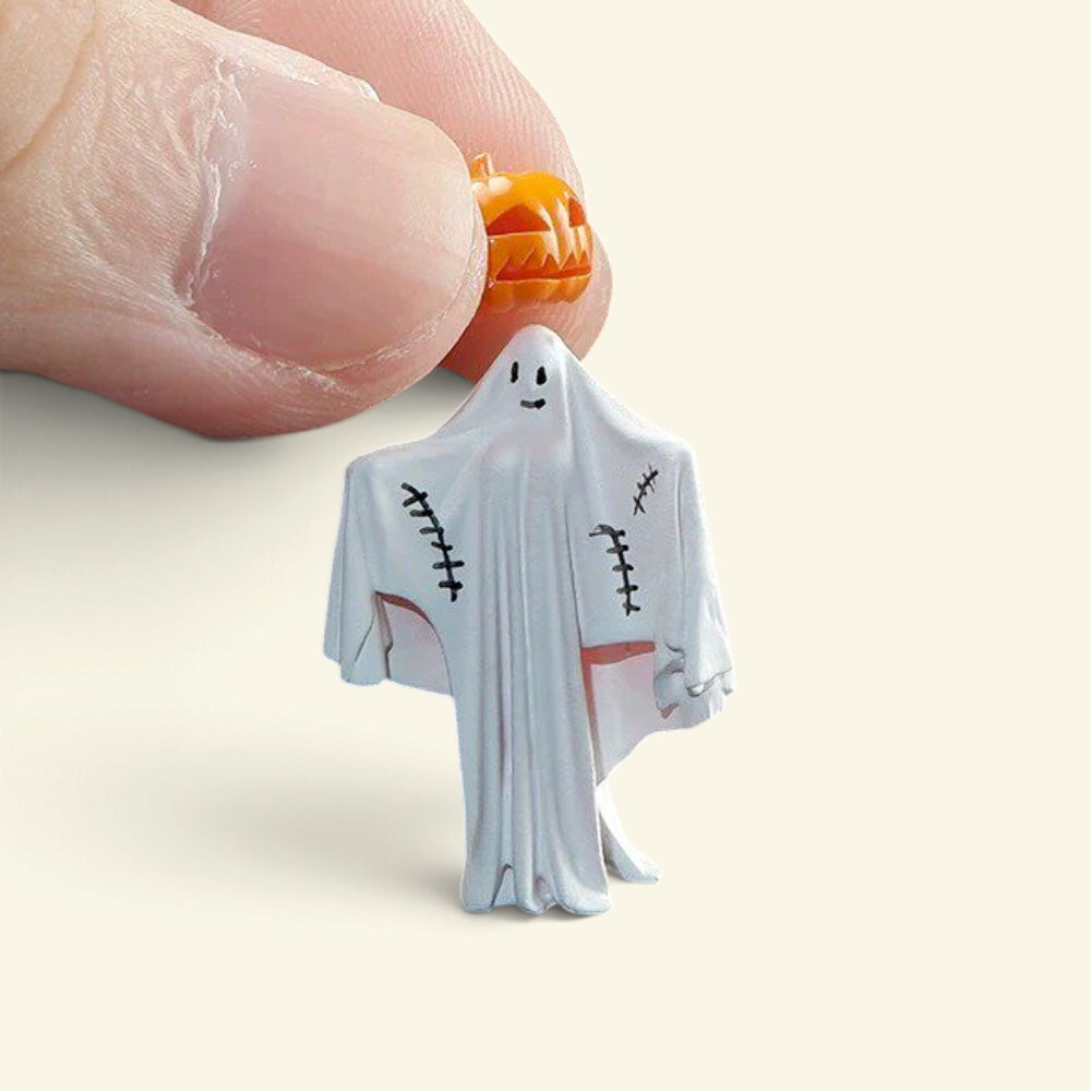 two fingers holding the pumpkin-head ghost figure by its pumpkin