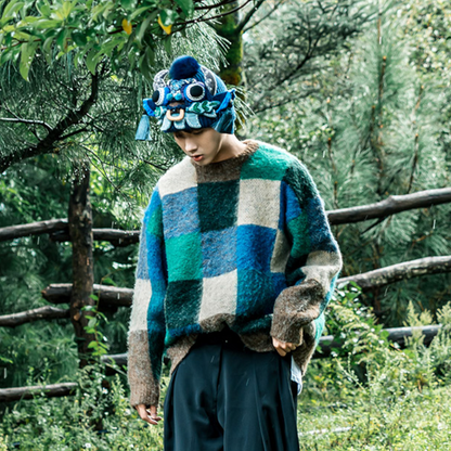 the ox head beanie in blue worn outdoors in a green forest setting, uggaz