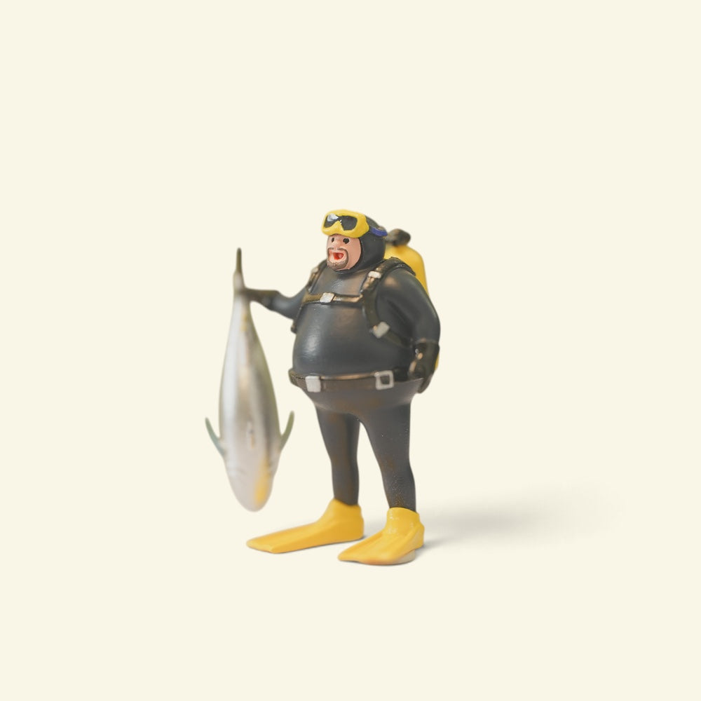 three-quarter view of the diver showing his yellow air tank, weight belt and the tuna at his side