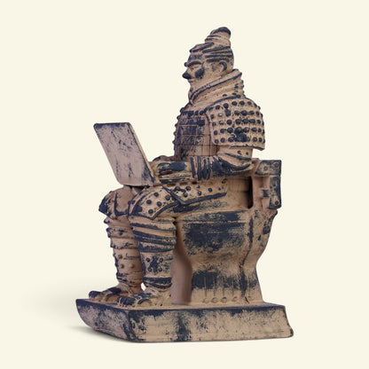 terracotta warrior figurine sitting on a toilet in full armor, typing on an open laptop on his knees, three-quarter side view on a cream background, clay tan with dark weathering