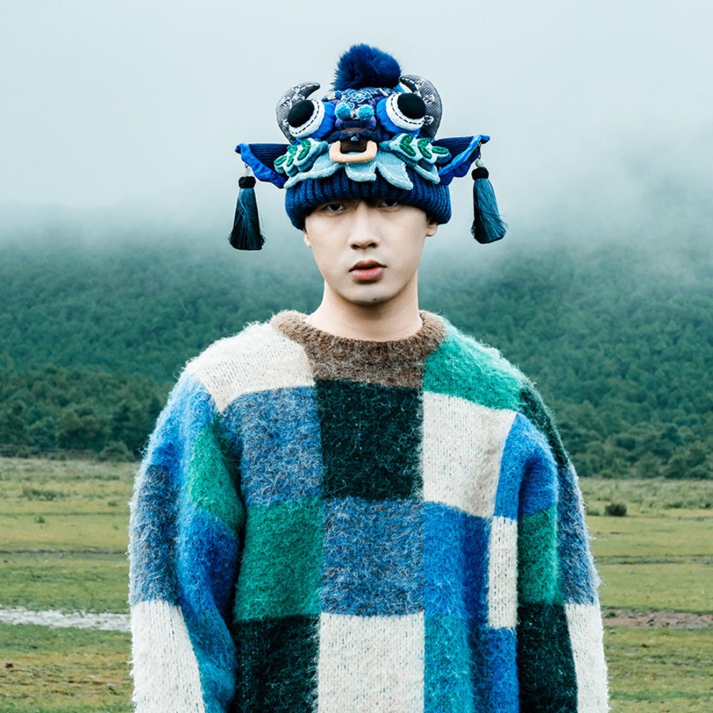 the ox head beanie in blue worn outdoors in a foggy mountain landscape, uggaz