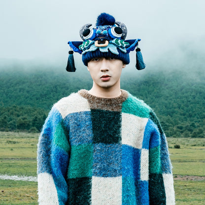 the ox head beanie in blue worn outdoors in a foggy mountain landscape, uggaz