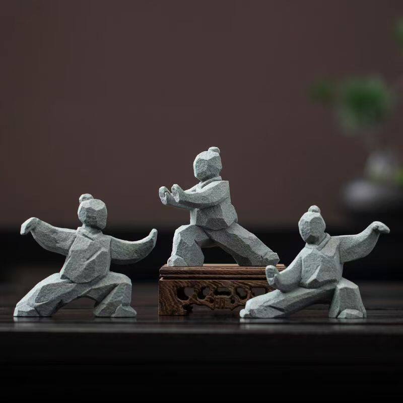 the slow masters – three tai chi figurines, one displayed on a carved wooden stand, uggaz