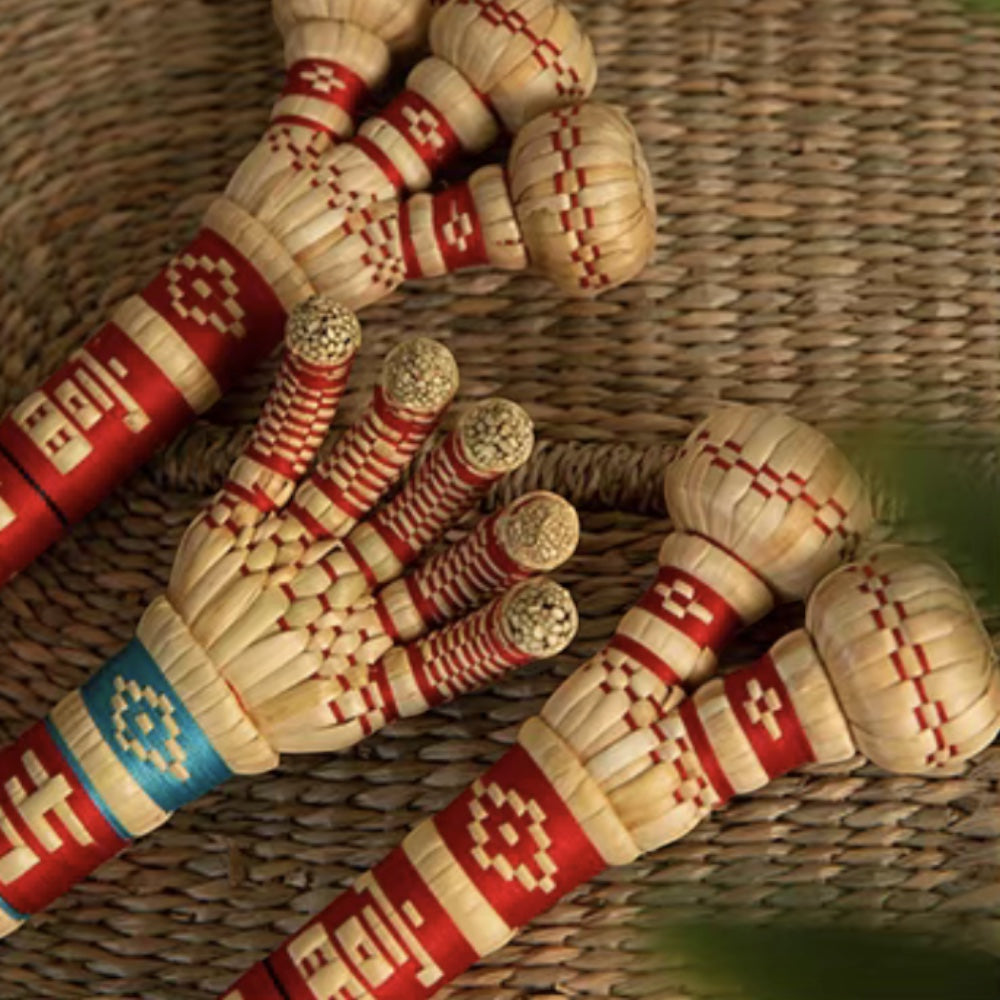 single-, double-, and triple-head sorghum hammers laid together on a woven mat, uggaz